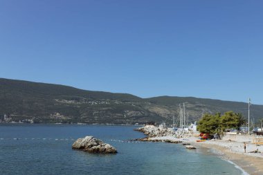 Herceg Novi, Karadağ - 15.09.202: Adriyatik 'in deniz kıyısındaki Kotor Koyu' nda güneşli bir günde yıkanan insanlar, Akdeniz manzarası. Ünlü turizm, eğlence ve hafta sonu konsepti