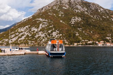 Perast, Karadağ - 15.09.2021: Turistler Kotor boka körfezindeki Gospa od skrpela adasına yat ile gittiler. Roma Katolik Kilisesi, adadaki kayalıklardaki leydimiz. 