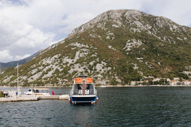 Perast, Karadağ - 15.09.2021: Turistler Kotor boka körfezindeki Gospa od skrpela adasına yat ile gittiler. Roma Katolik Kilisesi, adadaki kayalıklardaki leydimiz. 