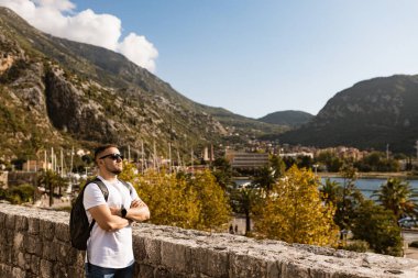 Adam Karadağ 'daki Kotor eski duvar kalesinde duruyor. Unesco 'nun dünya mirası. Avrupa seyahat alanı. Tatil konsepti. Adriyatik Denizi 'nde turizm. Sırbistan 'ın Balkanlar, kale ve liman tarihi