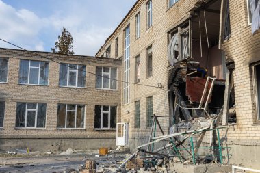 Barmashovo, Ukrayna... 18 Mart 2022 Ukrayna 'ya karşı Rusya Savaşı. İstila kavramı. Bir köyün merkezinde yakılmış ve hasar görmüş bir okul. Bomba patlamasından sonra duvardaki delikler. Kırık pencereler.