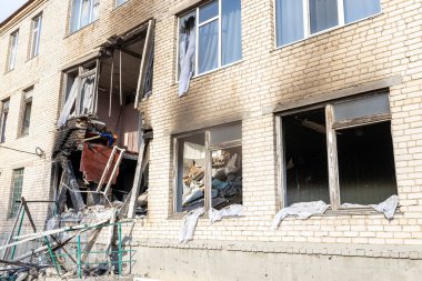 Barmashovo, Ukrayna... 18 Mart 2022 Ukrayna 'ya karşı Rusya Savaşı. İstila kavramı. Bir köyün merkezinde yakılmış ve hasar görmüş bir okul. Bomba patlamasından sonra duvardaki delikler. Kırık pencereler.