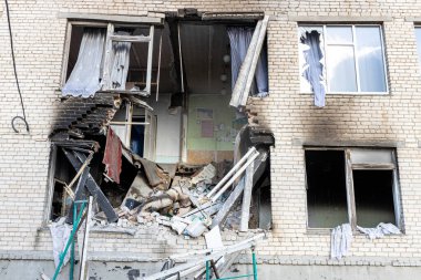 Barmashovo, Ukrayna... 18 Mart 2022 Ukrayna 'ya karşı Rusya Savaşı. İstila kavramı. Bir köyün merkezinde yakılmış ve hasar görmüş bir okul. Bomba patlamasından sonra duvardaki delikler. Kırık pencereler.