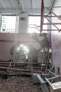 Barmashovo, Ukrayna... 18 Mart 2022 Ukrayna 'ya karşı Rusya Savaşı. Rus istilası kavramı. Spor salonundaki iki bombalı patlamadan sonra bir okulda bombalandı ve yıkıldı. Duvardaki delikler 