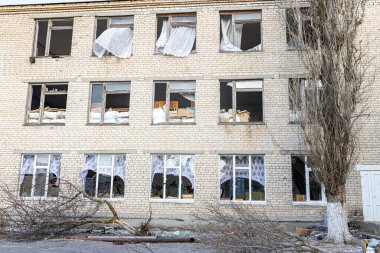 Barmashovo, Ukrayna... 18 Mart 2022 Ukrayna 'ya karşı Rusya Savaşı. Rus istilası kavramı. Spor salonundaki iki bombalı patlamadan sonra bir okulda bombalandı ve yıkıldı. Hasarlı pencereler