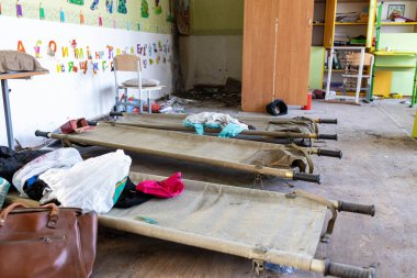 Barmashovo, Ukrayna... 18 Mart 2022: Pislik ve çöp, Rus işgalinden sonra yarı tahrip edilmiş okul odasında sedyeli çöp. İnsanlar onlara 