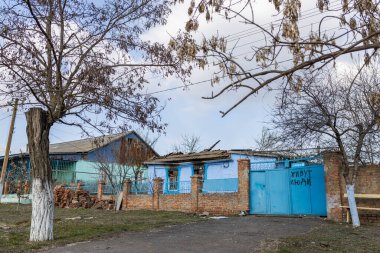 Barmashovo, Ukrayna... 18 Mart 2022 Ukrayna 'ya karşı Rusya Savaşı. Rus istilası kavramı. Köyün merkezinde yanmış ve harap olmuş bir ev. Kapılarda 