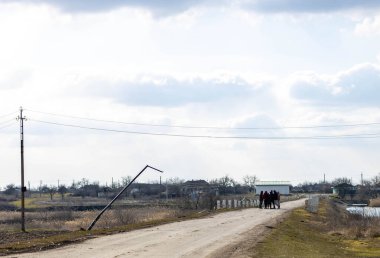 Barmashovo, Ukrayna - 18 Mart 2022: Rusya Ukrayna 'ya karşı savaş. İstila kavramı. Nehir yolundaki insanlar savaştan sonra elektrik kablolarını, elektrik direklerini ve elektrik direklerini tahrip ettiler.