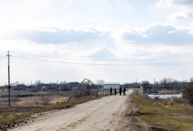 Barmashovo, Ukrayna - 18 Mart 2022: Rusya Ukrayna 'ya karşı savaş. İstila kavramı. Nehir yolundaki insanlar savaştan sonra elektrik kablolarını, elektrik direklerini ve elektrik direklerini tahrip ettiler.
