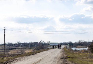 Barmashovo, Ukrayna - 18 Mart 2022: Rusya Ukrayna 'ya karşı savaş. İstila kavramı. Nehir yolundaki insanlar savaştan sonra elektrik kablolarını, elektrik direklerini ve elektrik direklerini tahrip ettiler.