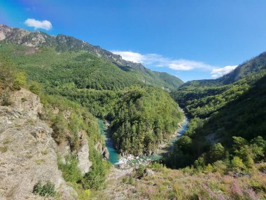 Dağları ve mavi gökyüzü olan güzel bir manzara.