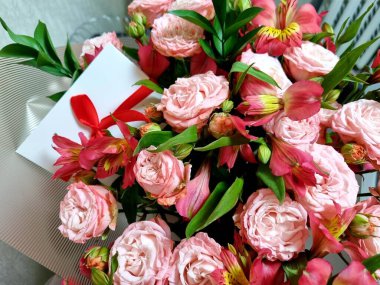 Kırmızı kurdeleli beyaz zarfın yakın plan fotoğrafı. Davetiye zarfı, hediye çeki, kart, düğün davetiyesi ve hediye. Hediye ve özen kavramı