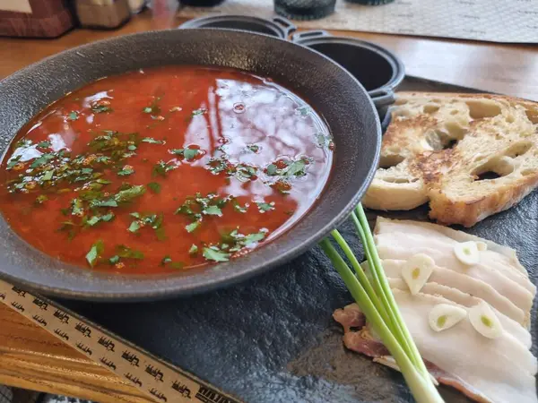 Geleneksel Ukrayna çorbası. Bir kase kırmızı pancar kökü çorbası, yanında beyaz krema ve domuz yağı. Pancar kökü çorbası. Geleneksel Ukrayna mutfağı. Lezzetli yemek kavramı