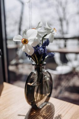 Bahar çiçekleriyle narsisli ve mavi vazolarla dolu küçük güzel bir vazo. natürmort. Uzayı kopyala Bağbozumu etkisi. İç dekorasyon kavramı.