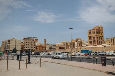 Dubai, BAE - 15 Nisan 2021: Dubai Creek kanalı yakınlarında yol manzarası. Güneşli bir yaz günü. BAE, Birleşik Arap Emirlikleri 'ndeki ünlü turizm merkezi. Arabalı yol, şehirde ulaşım. Metro istasyonu.