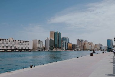 Dubai Creek kanalının Skyline manzarası. Eski ahşap tekneler ve rıhtımlar. Güneşli bir yaz günü. BAE, Birleşik Arap Emirlikleri 'ndeki ünlü turizm merkezi. Abra, su taksisi, Deira eski limanı. 