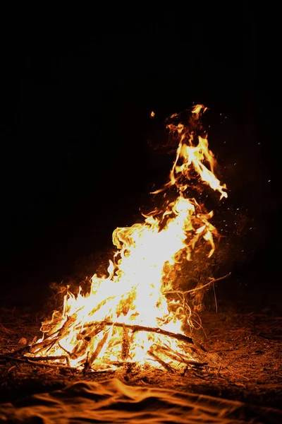 橙色的篝火 残余物篝火与火花在森林的雪地里夜夜靠近河边 烧焦的树枝烧柴火 大明亮的火焰 漂亮的特写背景 有选择的焦点 — 图库照片