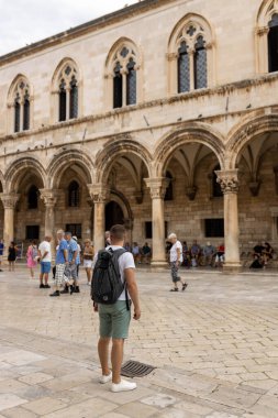 Dubrovnik, Hırvatistan - 21 Eylül 2021. Adam, Rönesans döneminden kalma binalarla Gotik Rektör 'ün sarayında duruyor. Eski kasaba UNESCO Dünya Mirası listesinde yer aldı. Kralın Şehri, Başkent Yedi Krallık