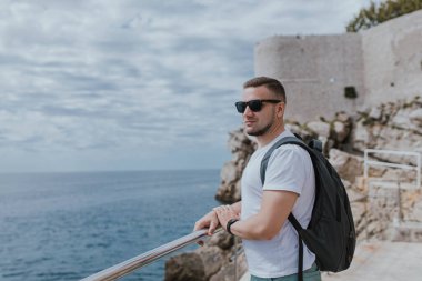 Adamın Adriyatik Denizi 'ndeki Lokrum Adası takımadaları üzerinde Dalmaçya' nın antik Hırvat kenti Dubrovnik 'te manzarası var. Seyahat ve doğa kavramı. uçurum ve sahil, mavi deniz ve dağ