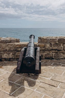 Budva, Karadağ - 18 Eylül 2021: Eski taştan kale üzerindeki eski bir top UNESCO Dünya Mirasları Listesi 'nde yer aldı. Turizm ve seyahat konsepti. Avrupalı turistlerin cazibesi