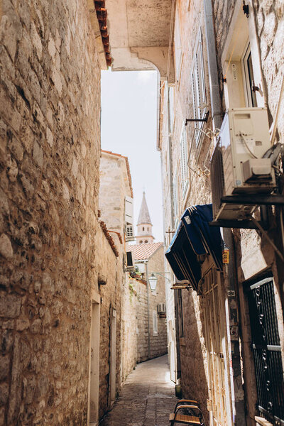Budva, Montenegro - September 18, 2021: narrow dark street in castle listed UNESCO World Heritage Sites. Tourism and traveling concept.  Attraction for european, world tourists, architecture concept 