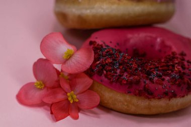 Pembe ve menekşe aromalı çörekler ve pembe begonya yapraklı haşhaş tohumu ve kuru ahududu ile renklendirilmiş serpiştirilmiş. Lezzetli, yağlı, yüksek kalorili tatlı yiyecekler. Seçici Odaklanma