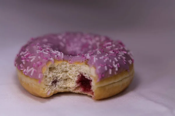 Donut Mit Violettem Sahnehäubchen Und Farbigen Streuseln Auf Weißem Hintergrund — Stockfoto