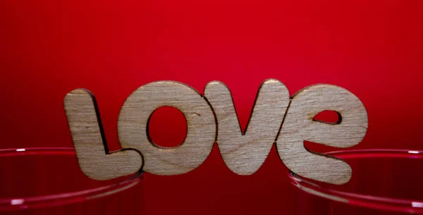 La palabra amor en letras de madera sobre un fondo rojo — Foto de Stock