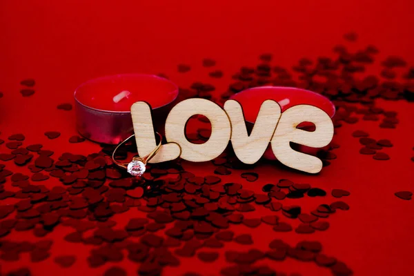 Prsten, slovo láska, svíčky a konfety — Stock fotografie