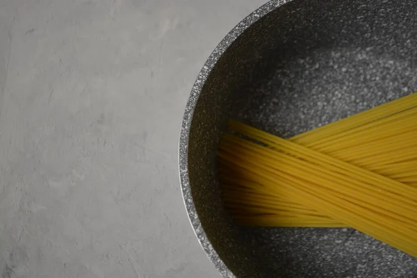 Esparguete cru envolto com corda em um fundo preto, close-up — Fotografia de Stock