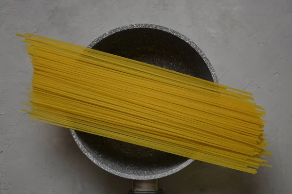 Raw spaghetti lindad med rep på en svart bakgrund, närbild — Stockfoto