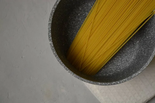 Raw spaghetti i krukor på en ljus bakgrund — Stockfoto