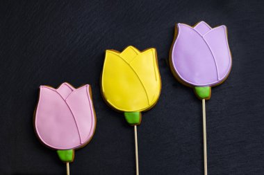 Siyah arka planda çok renkli zencefilli kek laleleri. Gıda tatlı arka plan