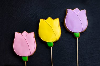 Siyah arka planda çok renkli zencefilli kek laleleri. Gıda tatlı arka plan