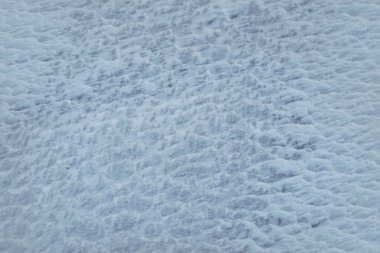 Sahada kar dalgalanmalarının dokusu yakın plan. Seçici odaklanma. Doğal mavi arkaplan.