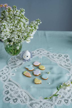 Paskalya yumurtaları ve bahar çiçekleriyle paskalya arkaplanı. Zencefilli kurabiye Yumurta şeklinde kurabiyeler ve Paskalya tavşanı.
