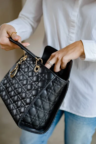 黒のバッグと流行の衣装の女性 屋外でバッグを持っている女の子 女性用ショルダーバッグ ファッションルックの女性の服 スタイリッシュな女性のベージュのハンドバッグ — ストック写真