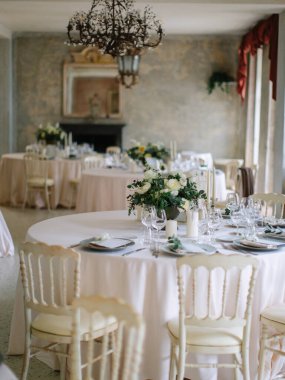 wedding decor, served tables, ivory, with candles, glasses, beautiful wooden tables, inside the Italian old Villa