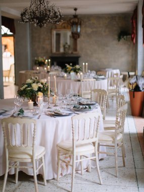 wedding decor, served tables, ivory, with candles, glasses, beautiful wooden tables, inside the Italian old Villa