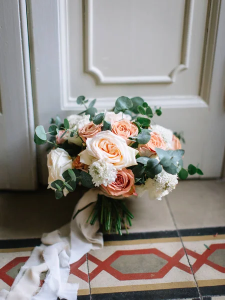 Wedding bridal bouquet of peony, roses, and eucalyptus.