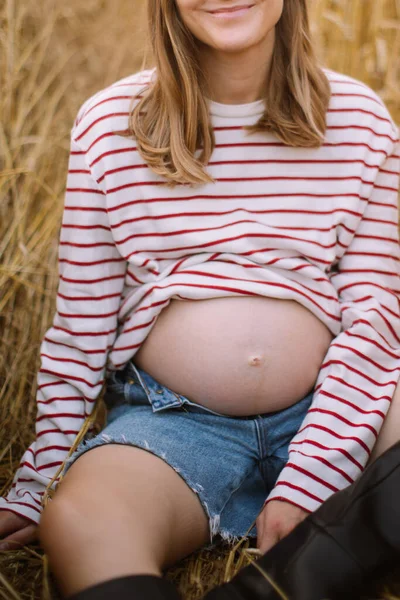 Een Zwangere Vrouw Met Blond Haar Een Gestreept Topje Spijkerbroek — Stockfoto