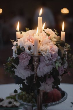 Restoran mumlar ve çiçeklerle süslenmiş. Mumlarla çiçek aranjmanı.