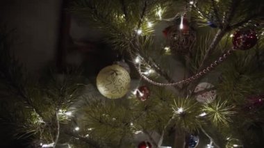 Güzel dekore edilmiş bir noel ağacı ve gece oturma odasında bokeh ışıkları. Geceleri odada Noel ağacı süslemeleri. Yılbaşı ve yeni yıl iç dekorasyonlu karanlık oda.. 