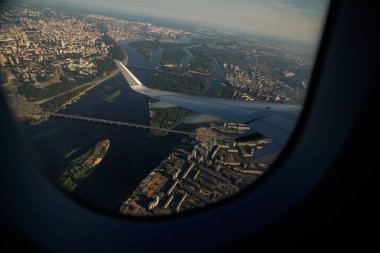 Kanattaki uçak penceresinden bak. Uçak inişe geçiyor. Uçak Penceresi Metropolitan Şehir Manzarası Üzerine İniyor.
