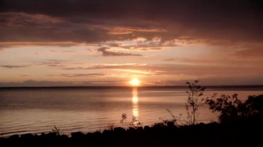 Karanlık ve dramatik fırtına denizin üzerinde gün batımını bulutlandırıyor. Gün batımında denizin üzerinde inanılmaz ışık huzmeleri. Zaman aşımı.