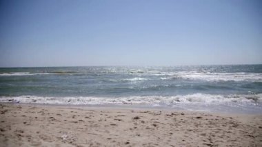 Plaj denizi Dalgalar sahili yıkıyor. Yaz günü kumsal deniz kum ve gökyüzü manzarası. Sahildeki deniz alanı.
