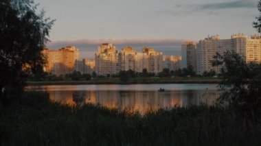 Gölün karşısındaki şehir manzarası. Şehir gün batımında göl boyunca yükseliyor..