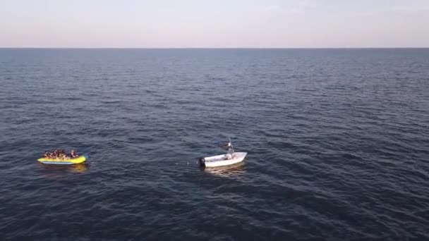 Filmagem Aérea Uma Lancha Rebocando Barco Banana Inflável Alta Velocidade — Vídeo de Stock