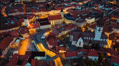 Günbatımında Romanya 'nın Sibiu kentinin tarihi kent merkezine kuşların bakış açısı. Evanjelik Katedrali ve Hued Meydanı 'nı, küçük meydanı ve büyük meydanı kapsayan İHA fotoğrafçılığı. Gün batımında Sibiu şehir merkezinin fotoğrafları
