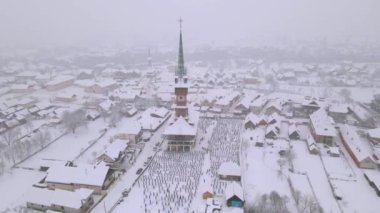 Aerial video of the wooden church at Sapanta cemetery in Maramures county, Romania in winter season. Footage was done from a drone while flying backwards from the church to reveal the entire area from above. 